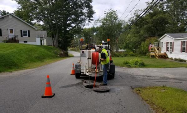 Cleaning under road sewer lines with high powered water jet